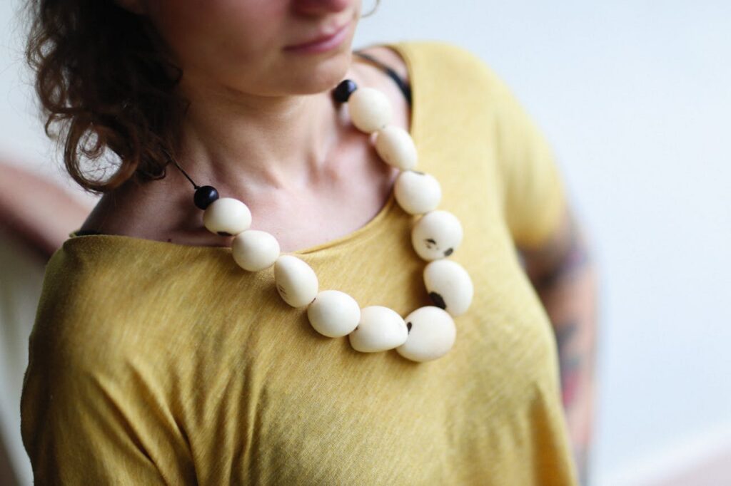 Close-up of a woman wearing a bold necklace with large beads.